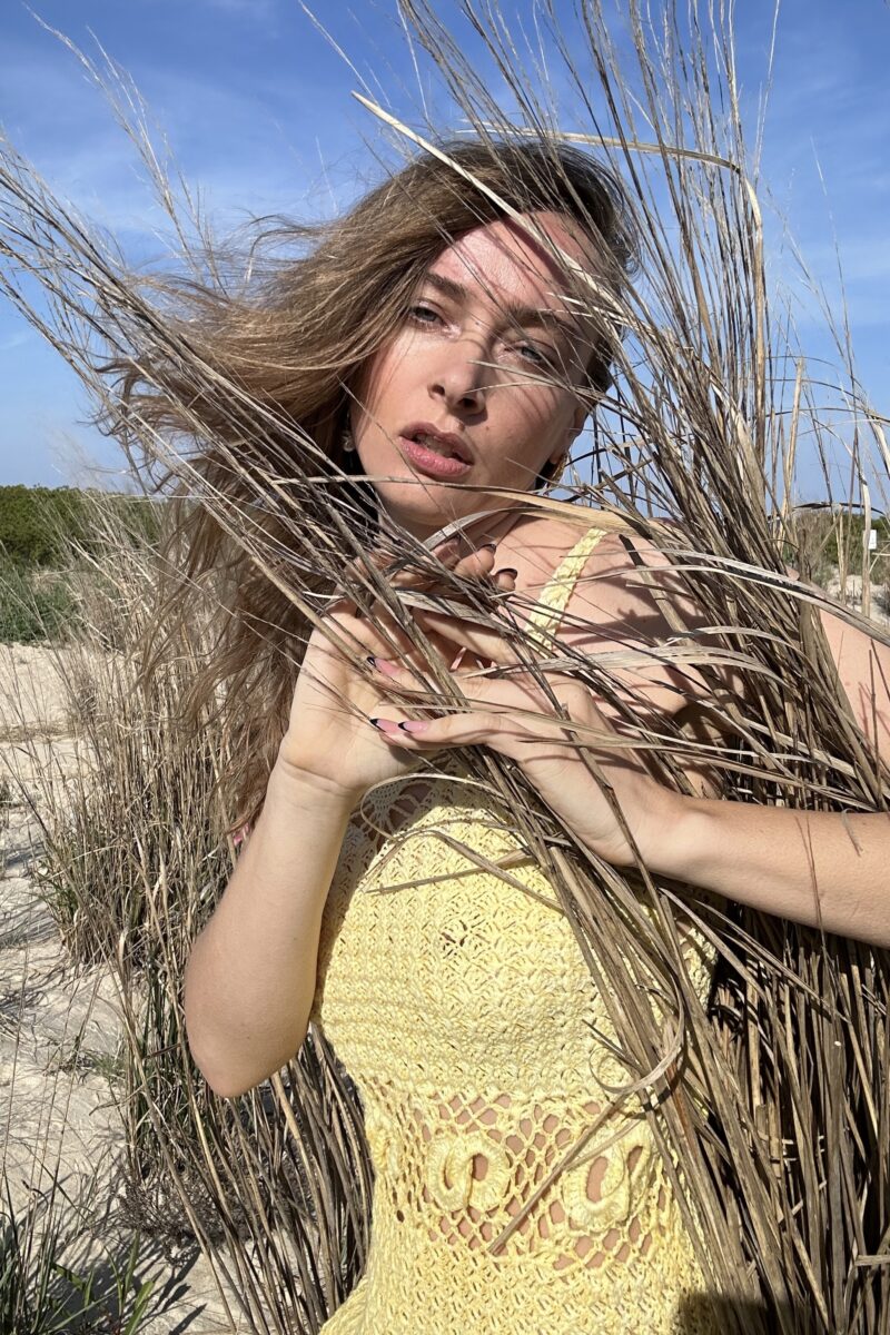 A fashion model outdoor with dried grass around