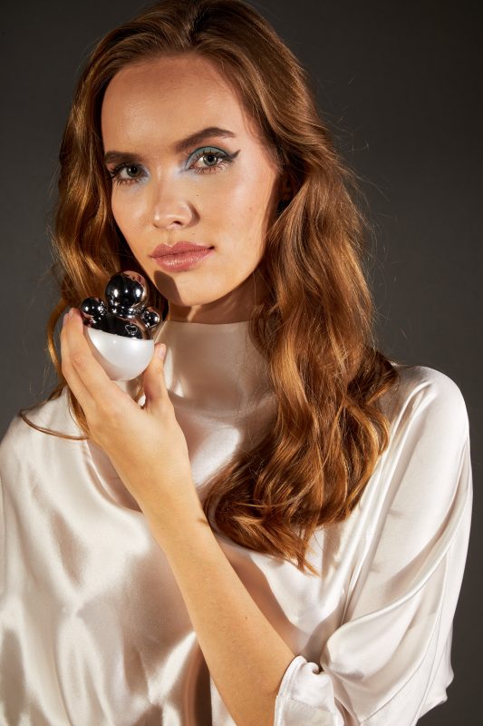 a model in white with IRFE MARSHMALLOW MUSK Eau de Parfum bottle