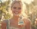 A gorgeous woman in the middle of a garden smiling and holding a glass perfume bottle with a Vanilla label