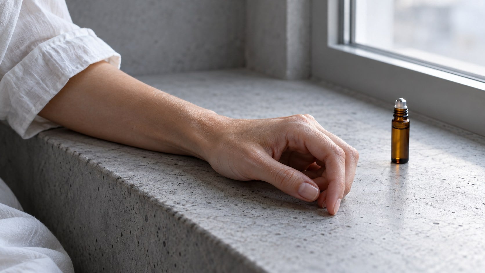 A relaxed hand and white cotton sleeve rest on a