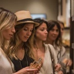 stylish women gathered around an elegant perfume